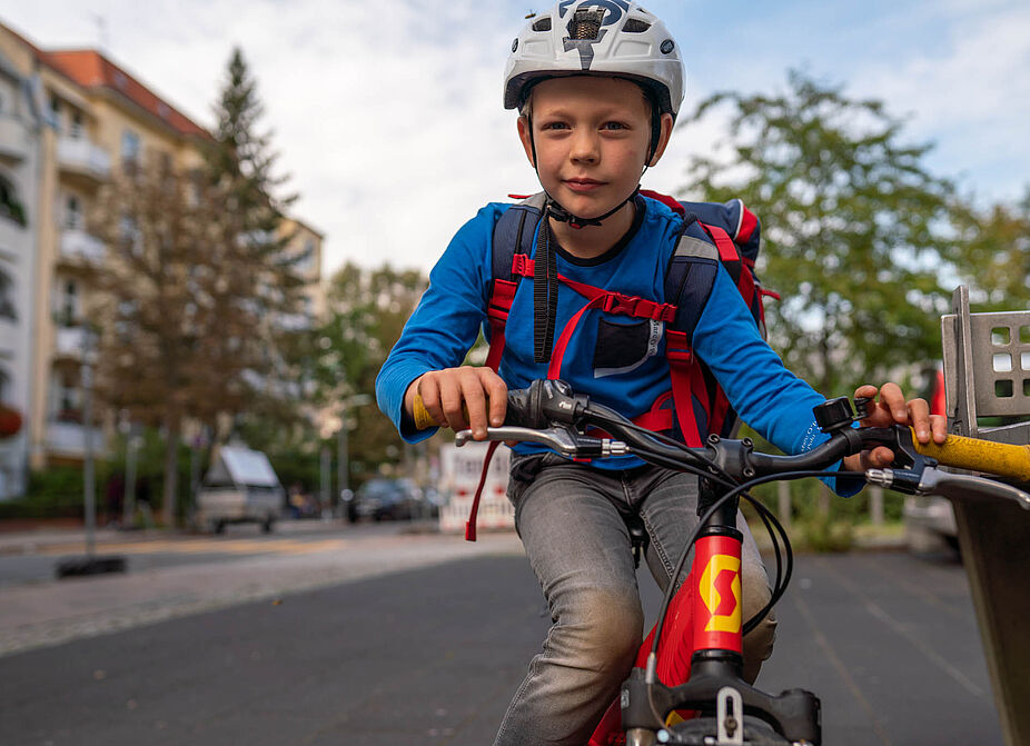 Junge mit Schulranzen auf dem Rad Ein Junge mit Schulranzen fährt mit dem Rad.
