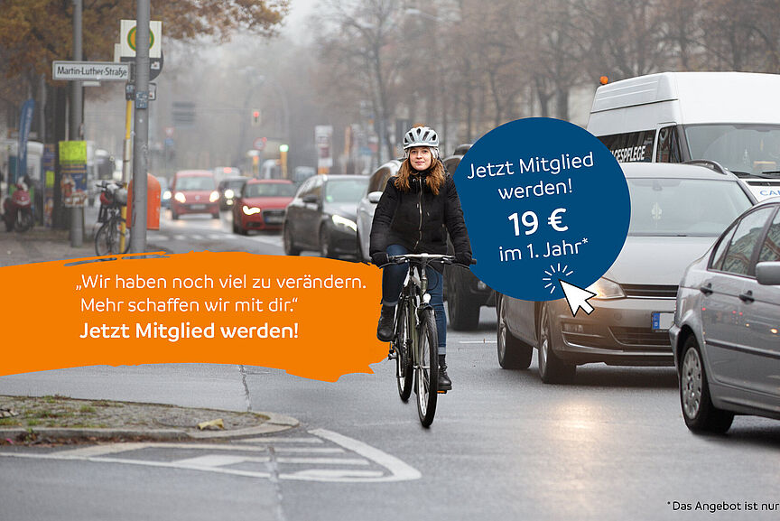 Einstiegsmitgliedschaft Winter 2025 Junge Frau fährt mit dem Fahrrad durch eine befahrene Straße, umgeben von vielen Autos an einem grauen Wintertag.