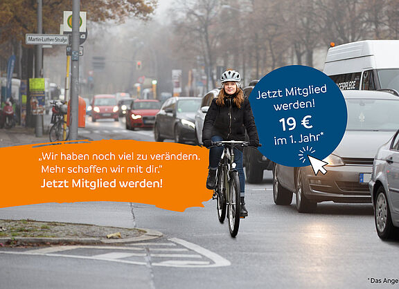 Junge Frau fährt mit dem Fahrrad durch eine befahrene Straße, umgeben von vielen Autos an einem grauen Wintertag.