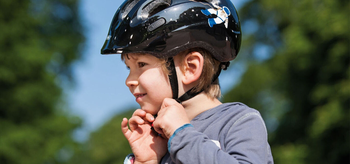 Ein Fahrradhelm muss dem Kind richtig passen und es muss wissen, wie es den Helm richtig aufsetzt und schließt.