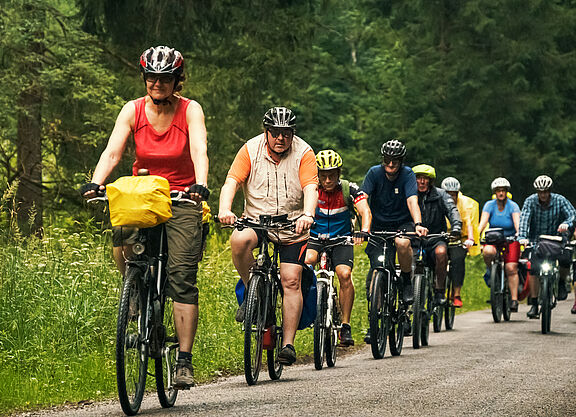 Gruppe von Menschen auf Fahrrädern im Wald