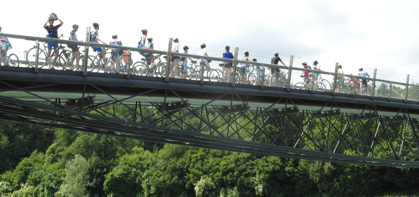 Radfahrerinnen auf Brücke Radfahrerinnen auf Brücke über Fluss