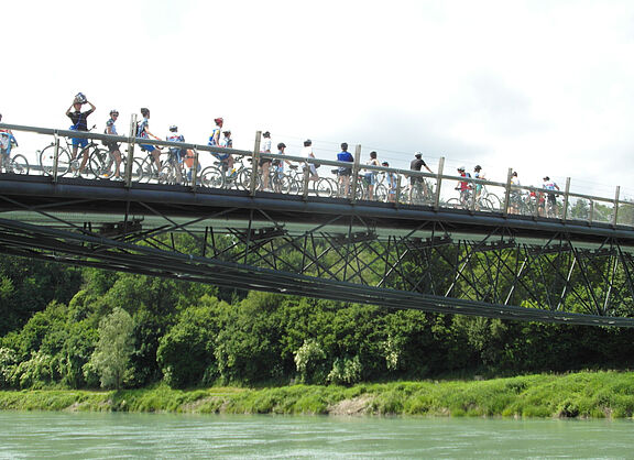 Radfahrerinnen auf Brücke über Fluss